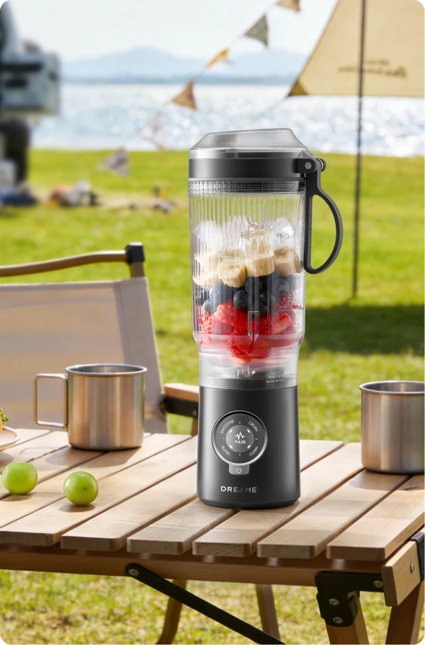 Dreame Portable Blender design senza fili su un tavolo da picnic che mescola bevande alla frutta all aperto
