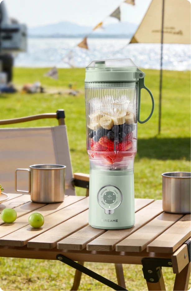 Dreame Portable Blender design senza fili su un tavolo da picnic che mescola bevande alla frutta all aperto