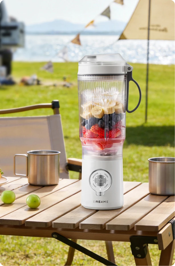 Dreame Portable Blender design senza fili su un tavolo da picnic che mescola bevande alla frutta all aperto
