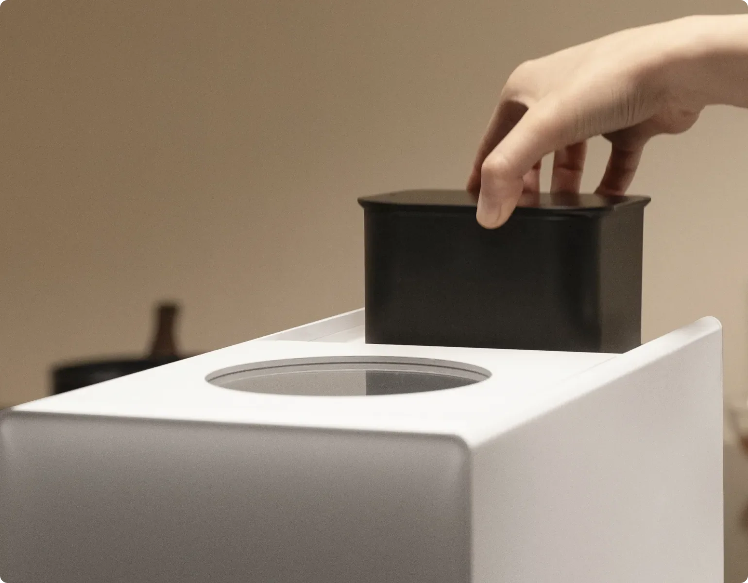 Una mano inserisce il filtro al carbone attivo nel Dreame SF25 WiFi, che inibisce gli odori con materiali purificanti di alta qualità direttamente alla fonte.